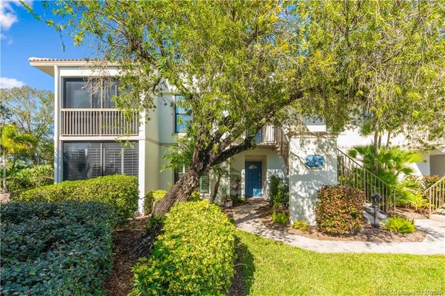 a view of a house with brick walls and a tree