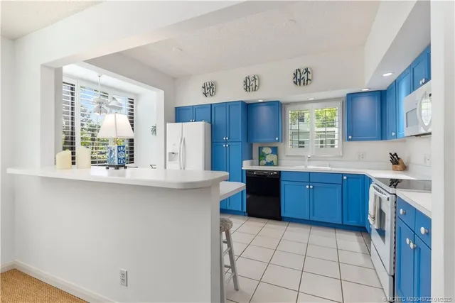 a kitchen with stainless steel appliances a sink a stove a refrigerator and cabinets
