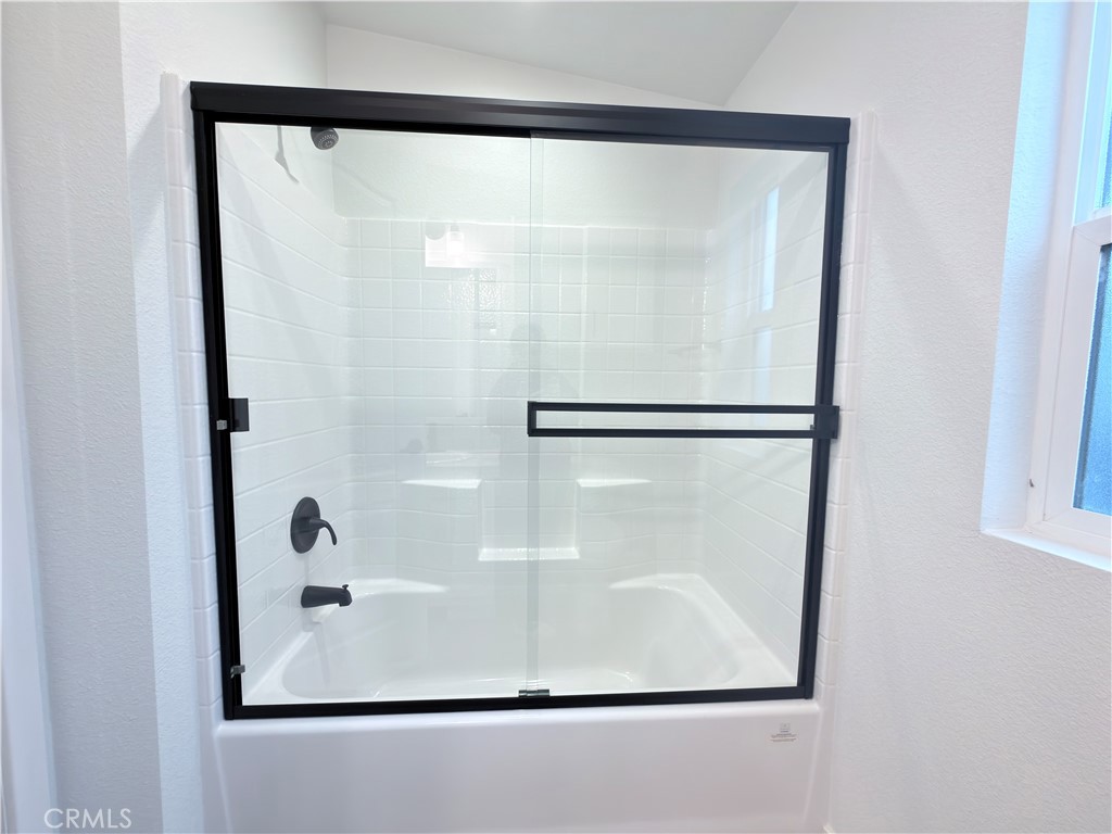 13061 Fairview Street, Unit 22 Garden Grove, CA 92843 - Photo 22 of 25 a bathroom with a glass shower door and mirror