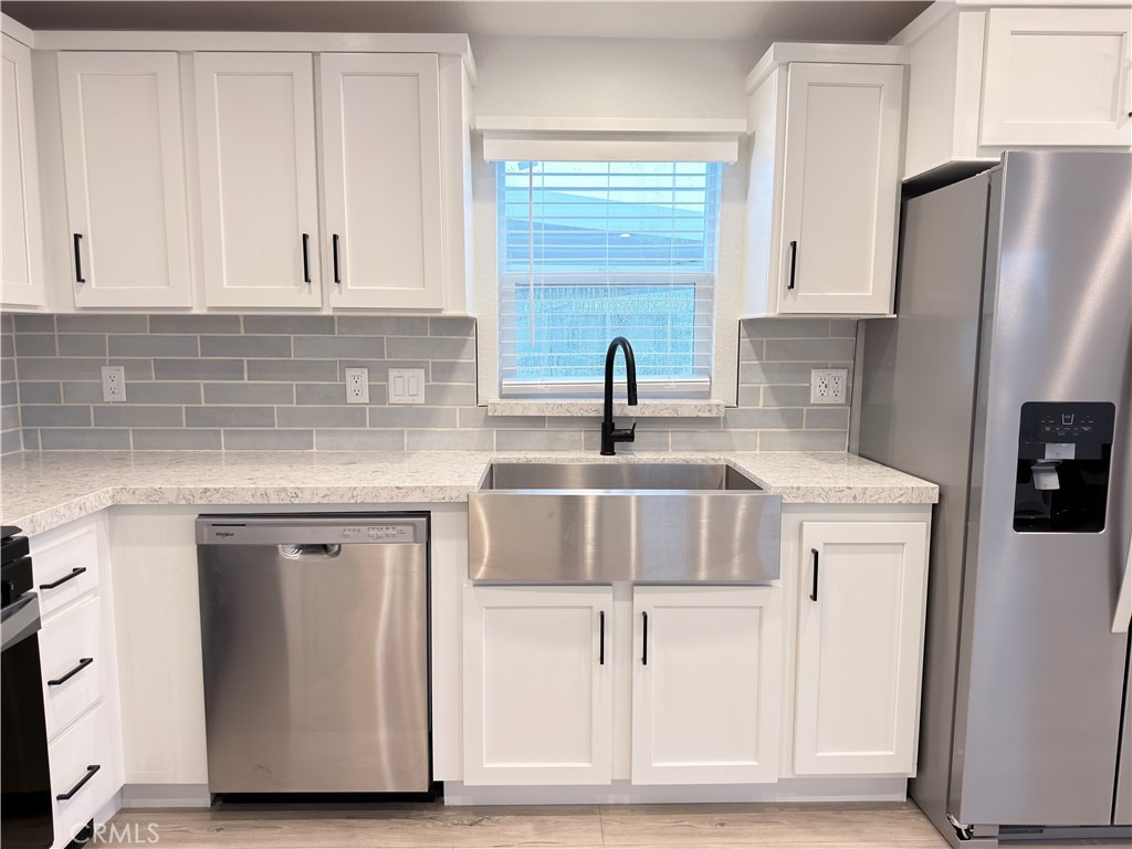 13061 Fairview Street, Unit 22 Garden Grove, CA 92843 - Photo 4 of 25 a kitchen with stainless steel appliances granite countertop a sink and a refrigerator