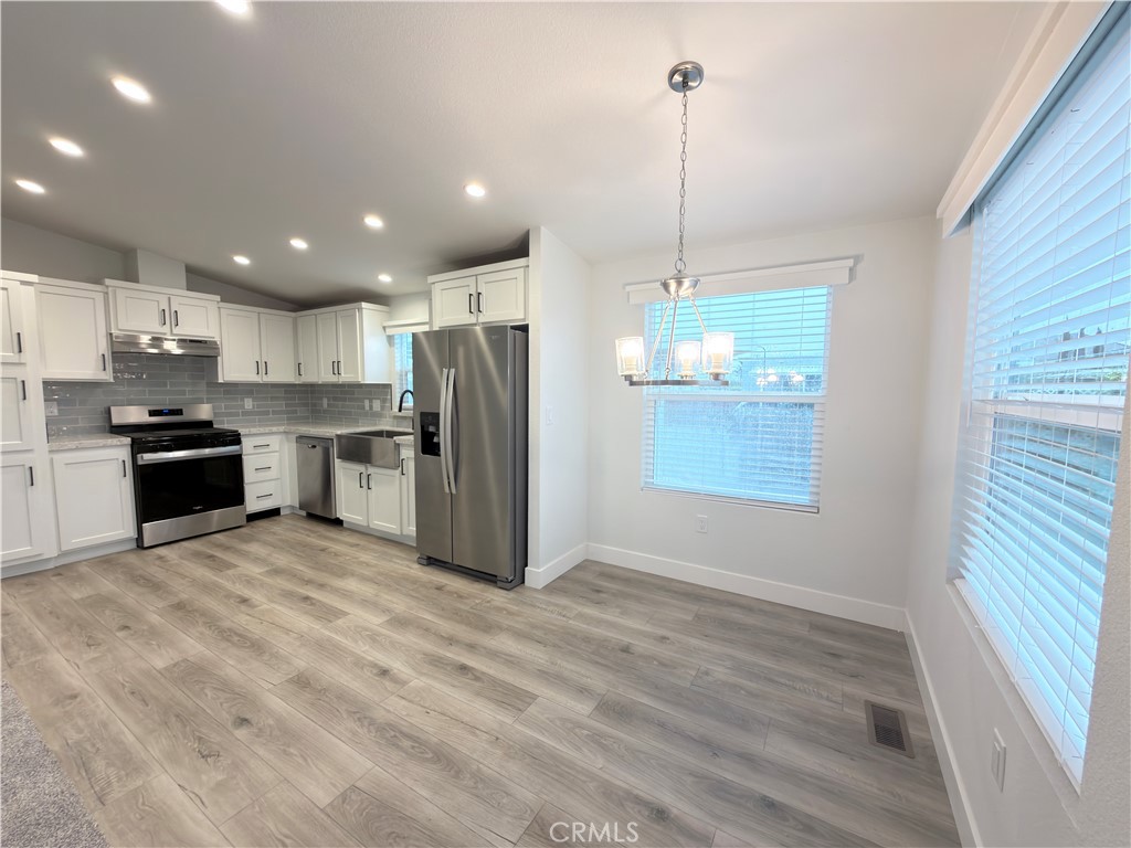13061 Fairview Street, Unit 22 Garden Grove, CA 92843 - Photo 6 of 25 a kitchen with stainless steel appliances kitchen island granite countertop a refrigerator and a sink
