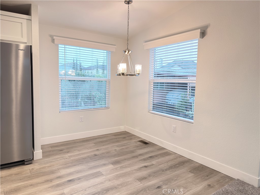 13061 Fairview Street, Unit 22 Garden Grove, CA 92843 - Photo 9 of 25 a view of an empty room with wooden floor and a window