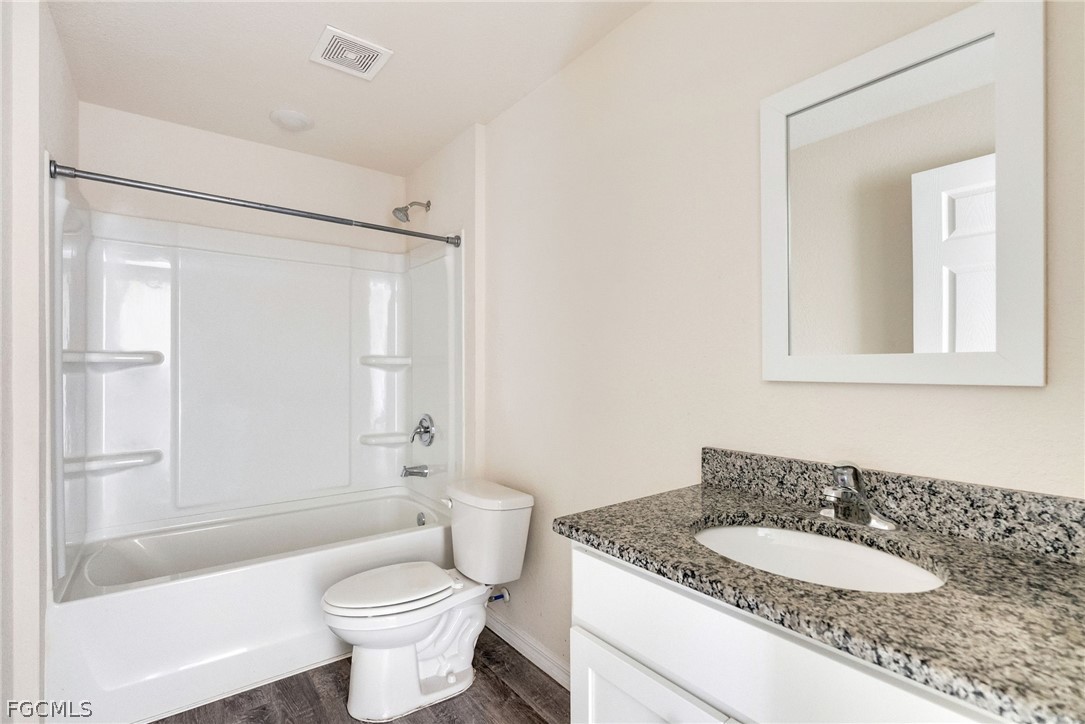 1405 Inwood Road LaBelle, FL 33935 - Photo 23 of 35 a bathroom with a granite countertop sink toilet mirror and shower