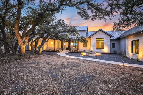 a front view of house with yard and trees around