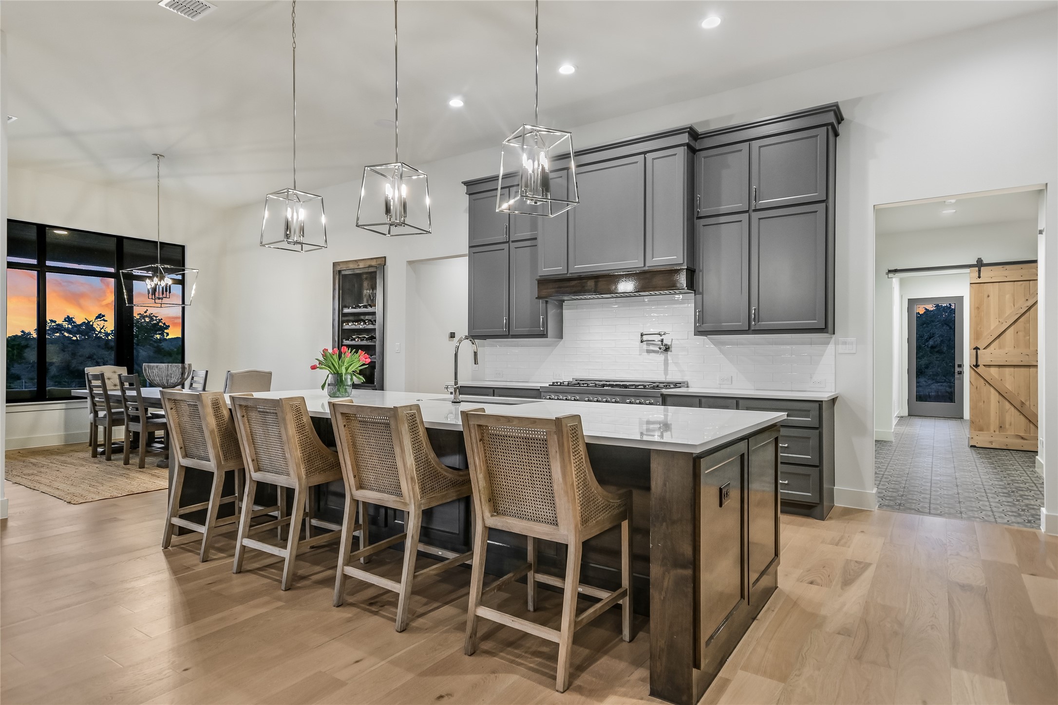 207 Gwendolyns Trail Wimberley, TX 78676 - Photo 8 of 40 a kitchen with stainless steel appliances granite countertop a stove top oven a sink dishwasher a dining table and chairs with wooden floor
