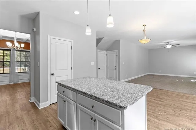 a large kitchen with stainless steel appliances granite countertop a stove a sink dishwasher a microwave oven with cabinets and wooden floor