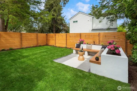 a view of backyard with table and chairs and wooden fence