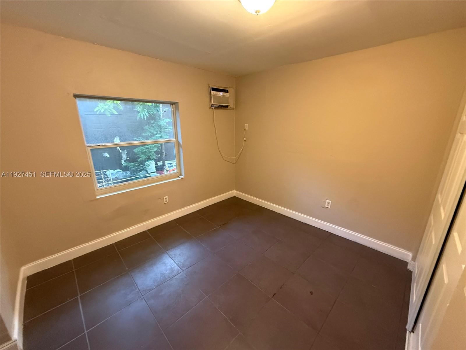1129 Northwest 29th Street, Unit B Miami, FL 33127 - Photo 3 of 7 an empty room with a window