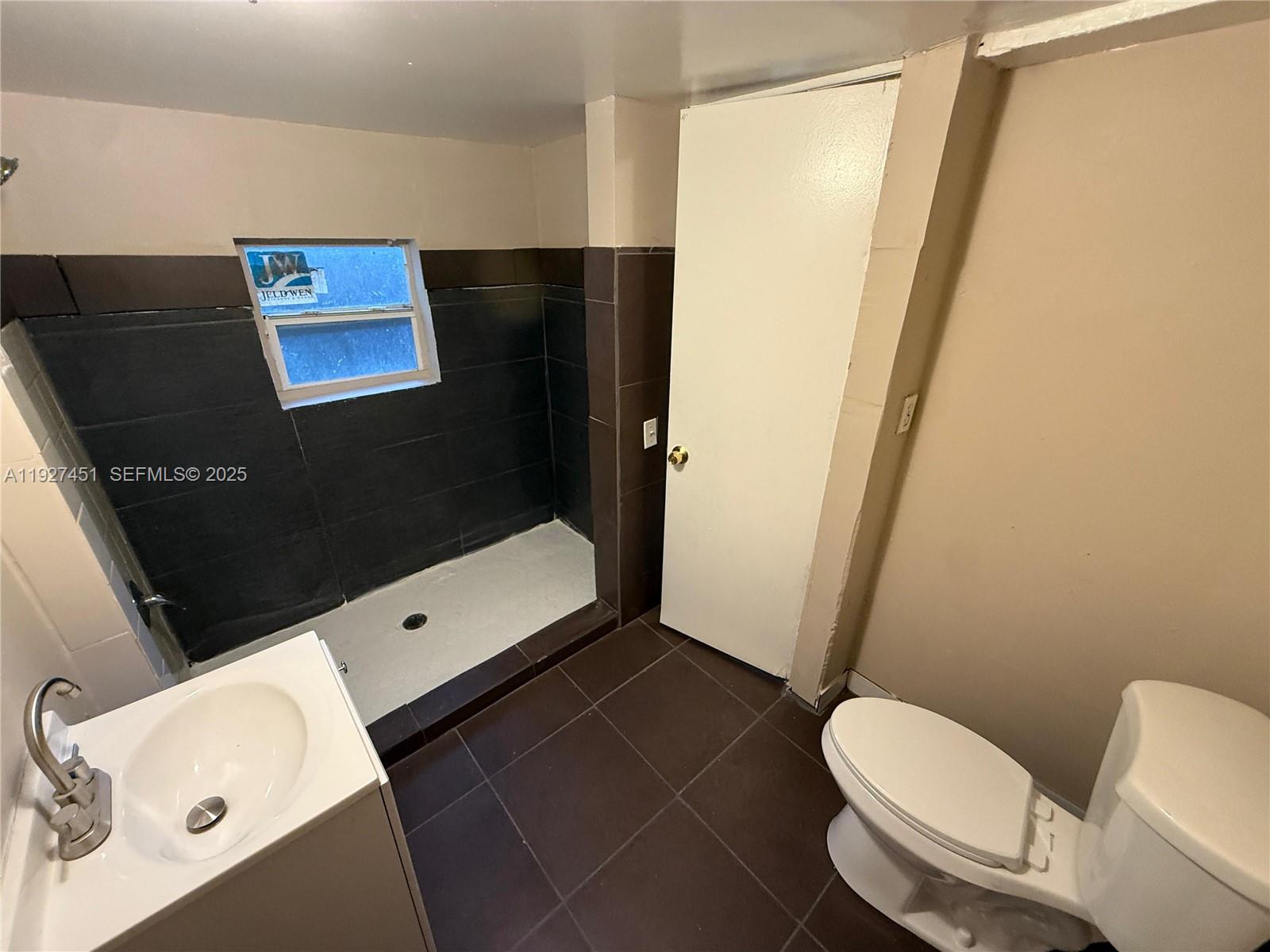1129 Northwest 29th Street, Unit B Miami, FL 33127 - Photo 5 of 7 a bathroom with a toilet and a shower