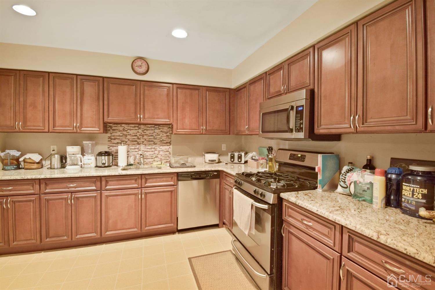 119 Redpine Loop Old Bridge, NJ 08857 - Photo 6 of 15 a kitchen with stainless steel appliances granite countertop a sink stove and cabinets