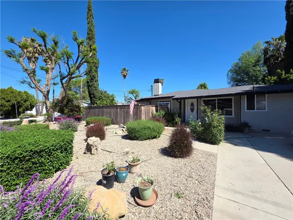 a view of a backyard with table and chairs potted plants