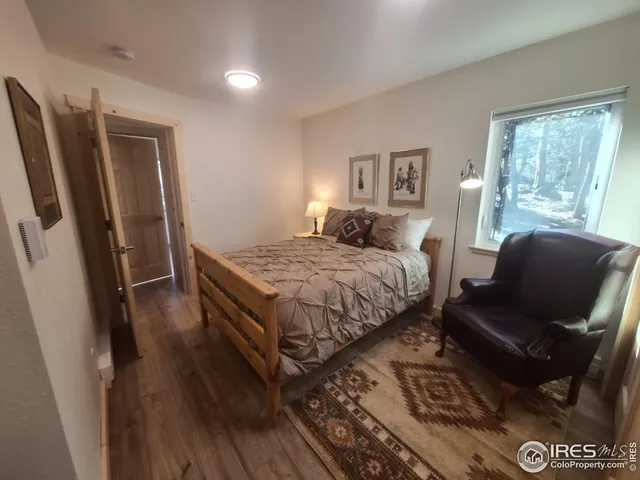 a bedroom with a bed wooden floor and window