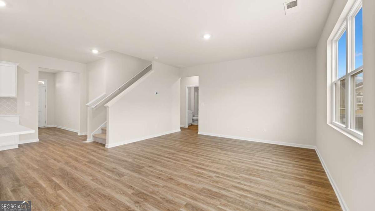 202 Cattle Drive Perry, GA 31069 - Photo 18 of 30 a view of an empty room with wooden floor and a window