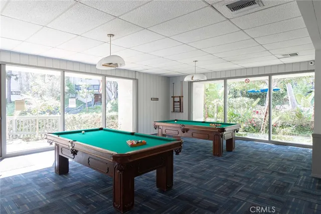 a room with pool table and windows