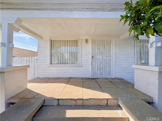 a bathroom with a tub and potted plant in front of it