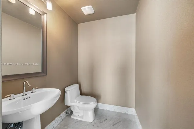 a white toilet sitting next to a white sink