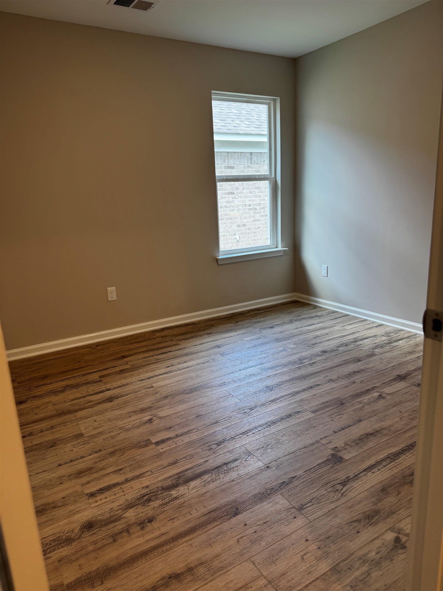5283 Zodiac Road Memphis, TN 38118 - Photo 10 of 13 Neutral tone wall paint, wood-finish flooring, white baseboards, and a double-hung window