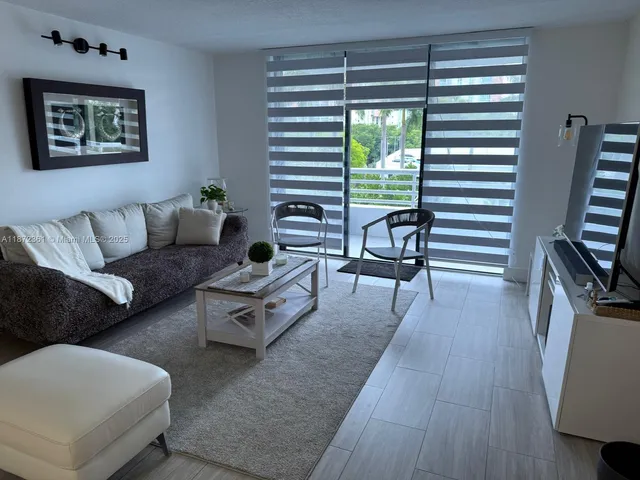 a living room with furniture a lamp and a flat screen tv