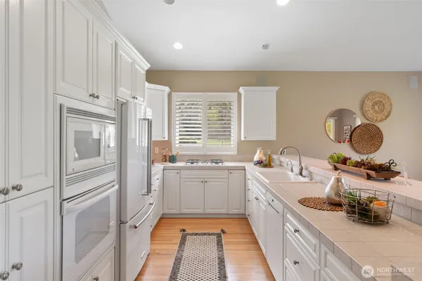 a large kitchen with kitchen island granite countertop a large window