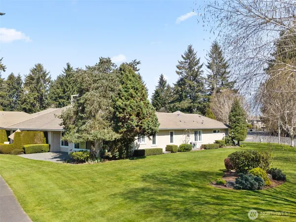 a front view of a house with a yard and trees