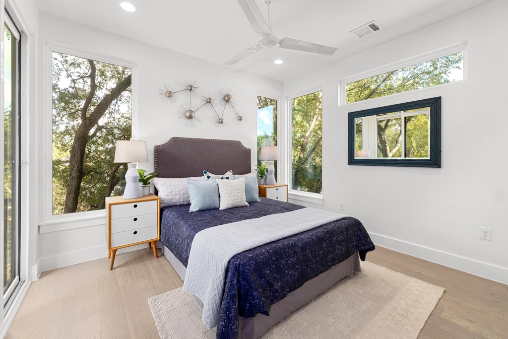 2909 East 13th Street, Unit 2 Austin, TX 78702 - Photo 10 of 23 Bedroom with light wood finished floors, multiple windows, a ceiling fan, and recessed lighting