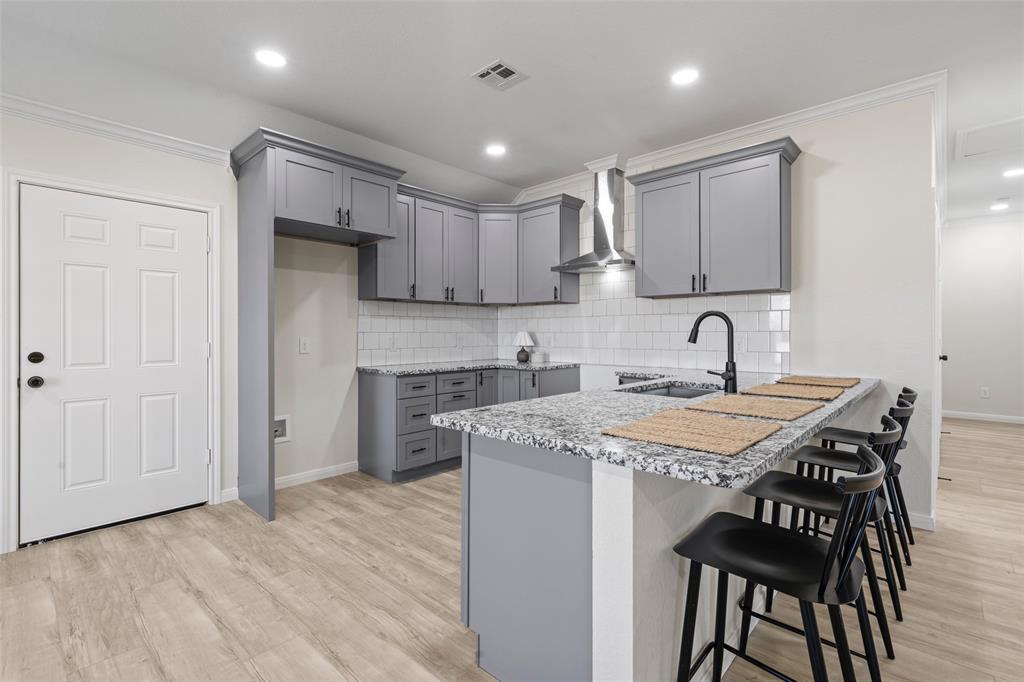 621 Delano Street Waco, TX 76704 - Photo 4 of 16 a kitchen that has a sink a center island stainless steel appliances and cabinets