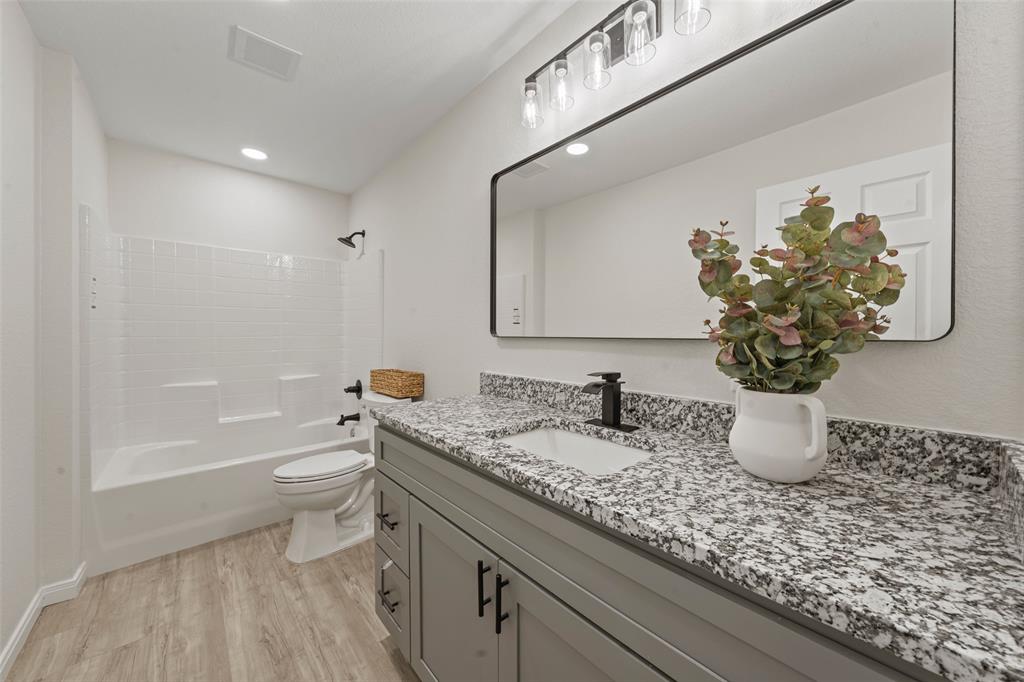 621 Delano Street Waco, TX 76704 - Photo 8 of 16 a bathroom with a granite countertop sink a toilet and bathtub