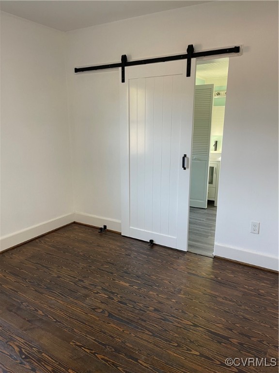 20020 Frog Level Road Ruther Glen, VA 22546 - Photo 18 of 32 Spare room with a barn door and dark wood-type flo
