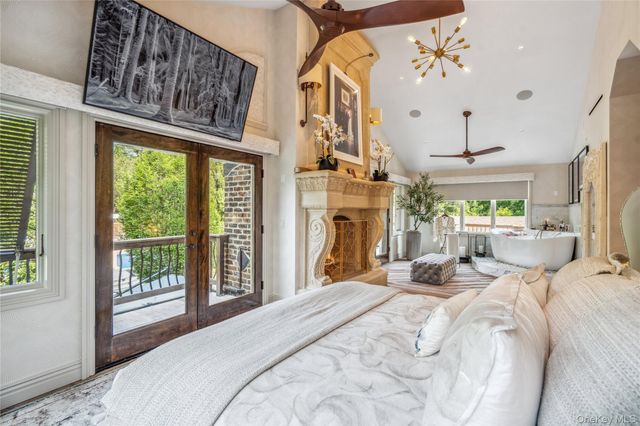 a bedroom with a bed a fireplace and a large window