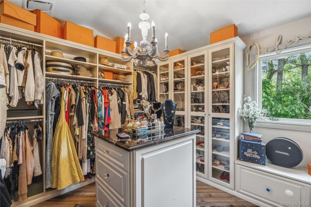 a view of walk in closet with clothes and shoes