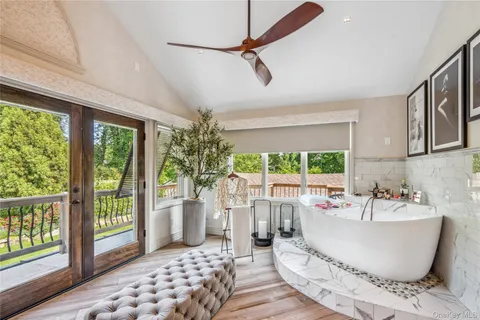 a white bath tub sitting in a bathroom next to a large window