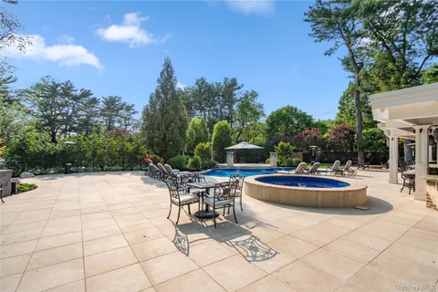 a backyard of a house with fountain table and chairs