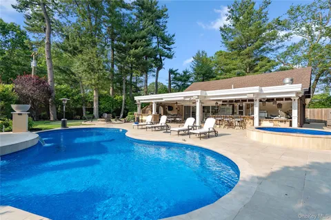 a view of a house with swimming pool and sitting area