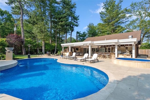 a view of a house with swimming pool and sitting area