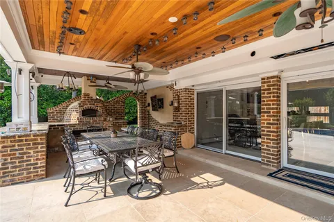 a patio with table and chairs and potted plants