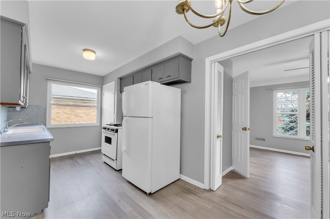 2915 Snow Road, Unit 2/UP Cleveland, OH 44134 - Photo 6 of 23 Kitchen featuring gray cabinetry, a white refrigerator, a white range, and wood-finish flooring