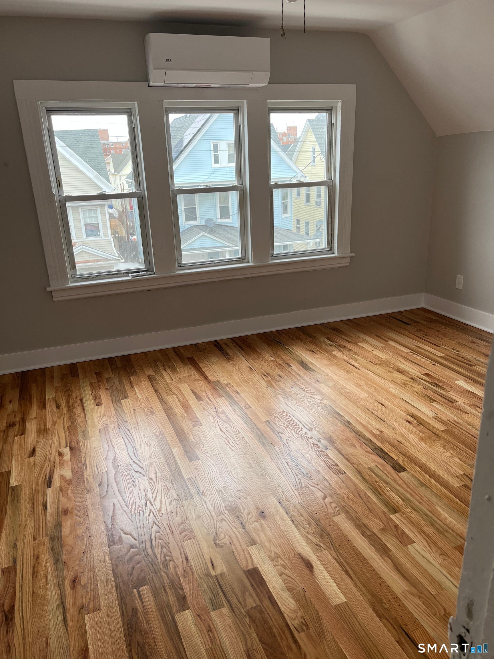 85 James Street, Unit 3 Bridgeport, CT 06604 - Photo 2 of 8 a view of an empty room with wooden floor and a window