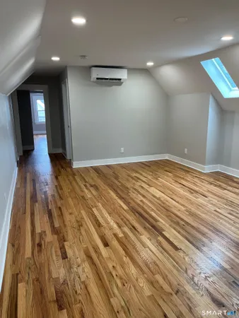 a view of empty room with wooden floor
