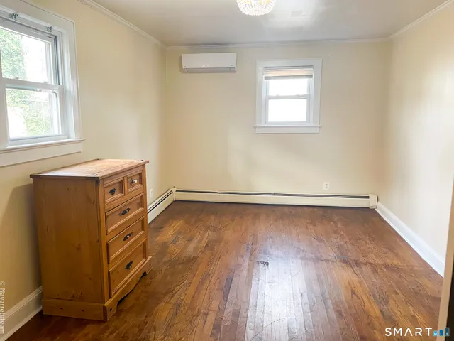 a view of a room with wooden floors and window