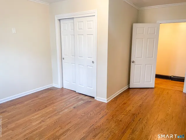 a view of an empty room with wooden floor