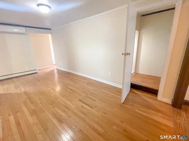 a view of empty room with wooden floor