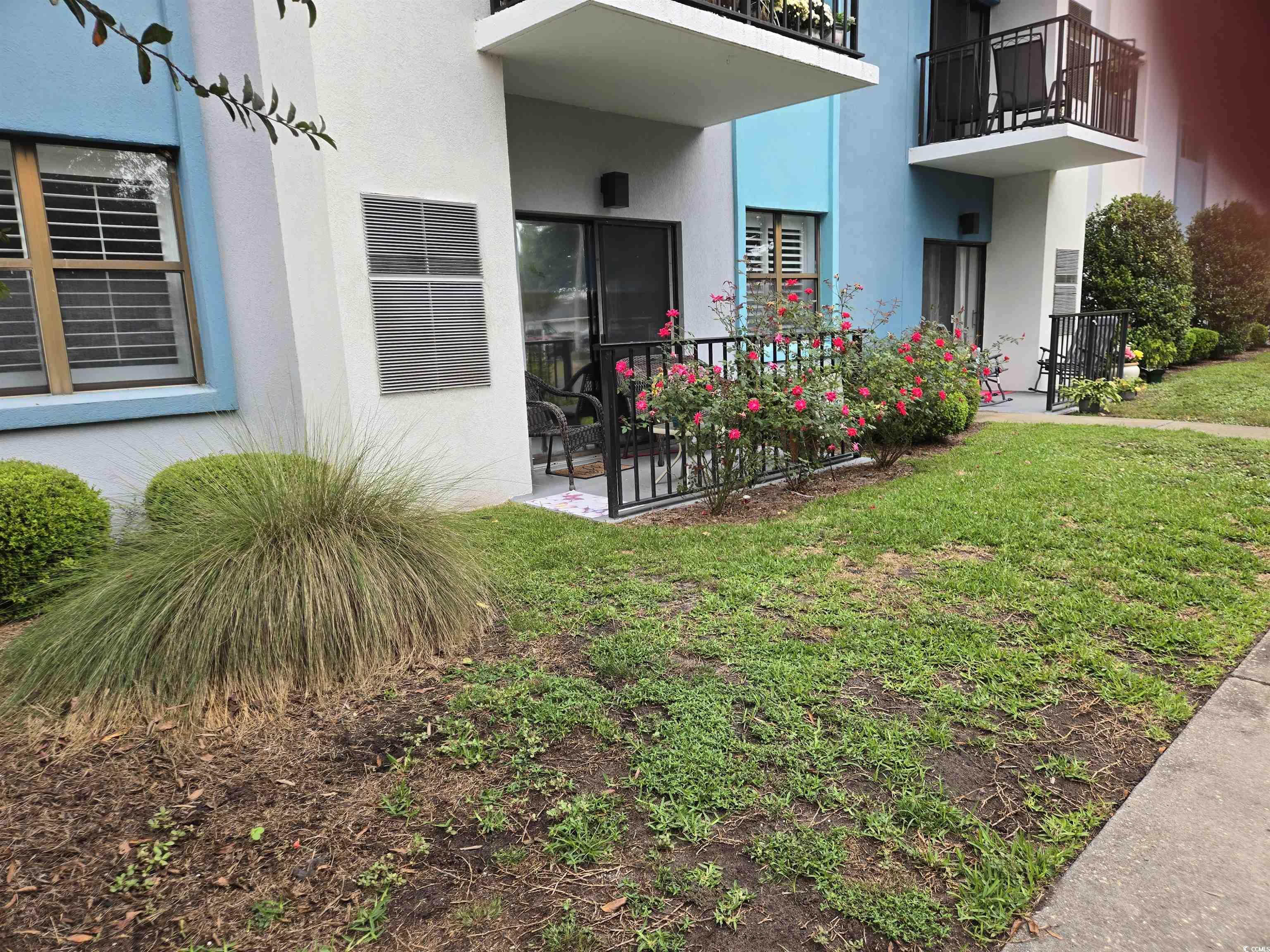 5001 Little River Road, Unit E108 Myrtle Beach, SC 29577 - Photo 2 of 25 Entrance to property featuring stucco siding and a lawn