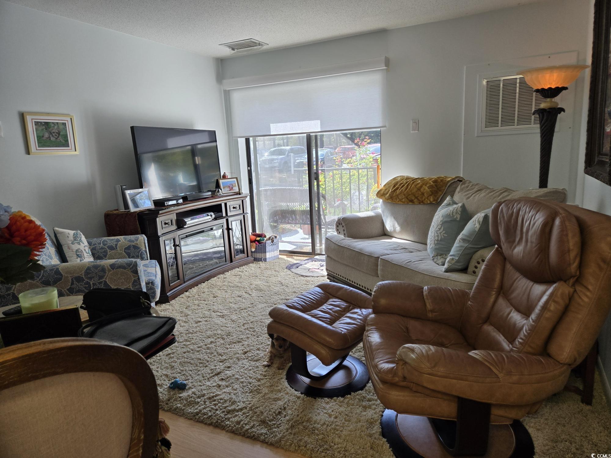 5001 Little River Road, Unit E108 Myrtle Beach, SC 29577 - Photo 21 of 25 Living area with a textured ceiling and wood finished floors