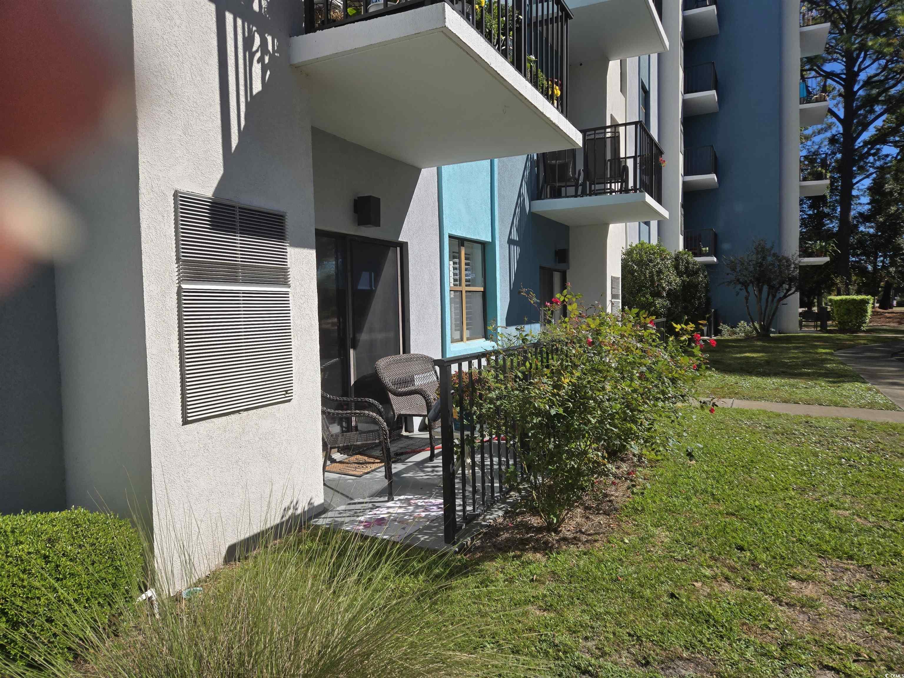 5001 Little River Road, Unit E108 Myrtle Beach, SC 29577 - Photo 25 of 25 Entrance to property featuring stucco siding and a lawn