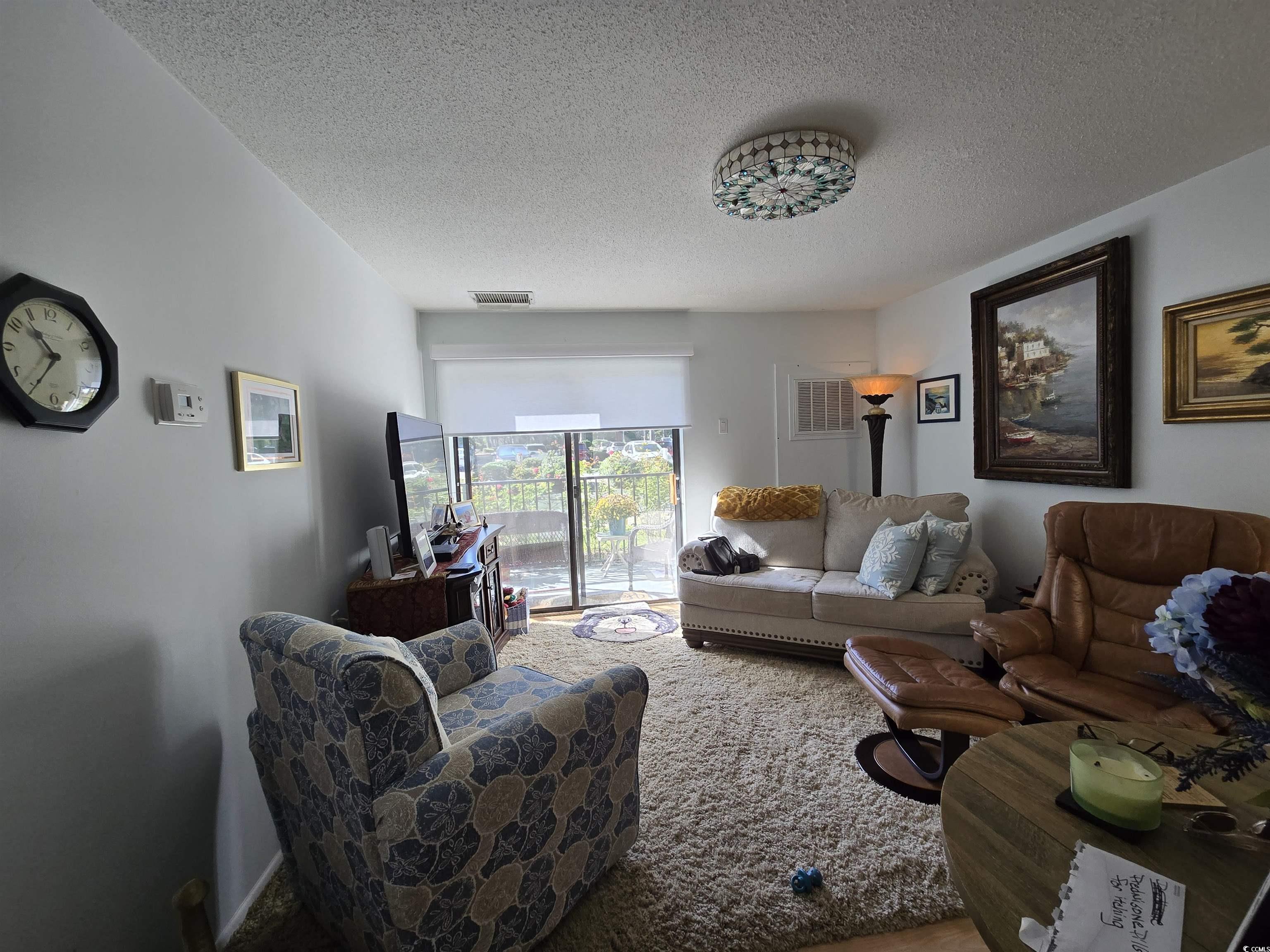 5001 Little River Road, Unit E108 Myrtle Beach, SC 29577 - Photo 4 of 25 Living room featuring a textured ceiling