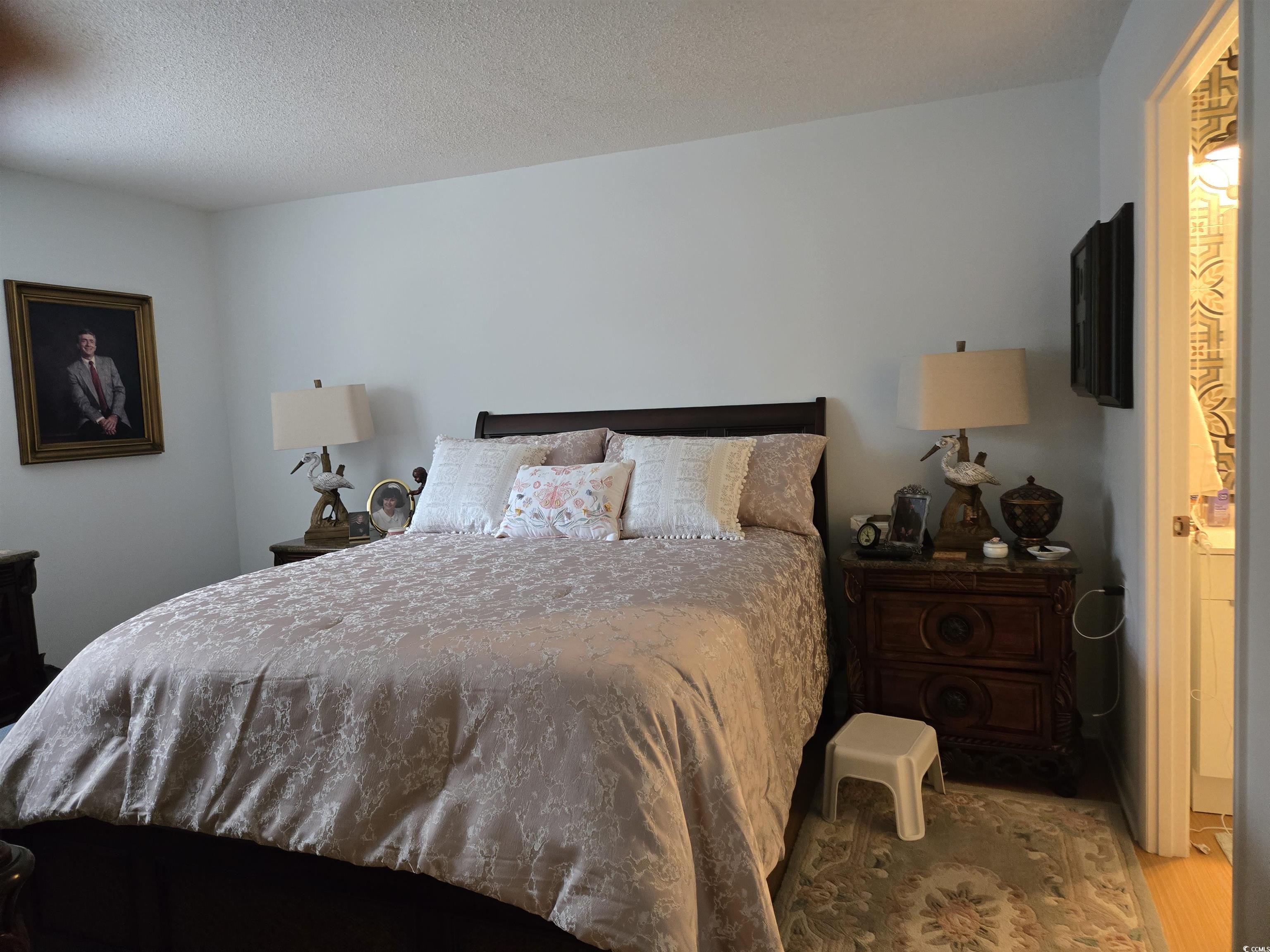 5001 Little River Road, Unit E108 Myrtle Beach, SC 29577 - Photo 10 of 25 Bedroom featuring wood finished floors and a textured ceiling