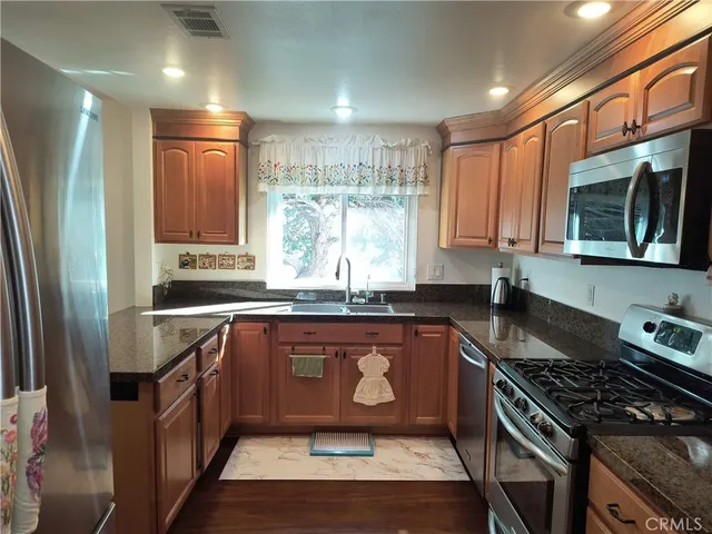 a kitchen with stainless steel appliances granite countertop a stove a sink and a microwave