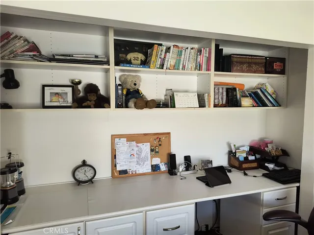 a view of workspace with lots of clutter on the wall and shelf