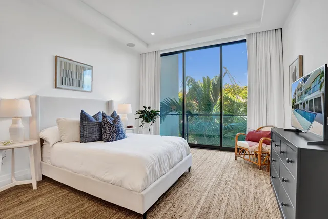 a bedroom with a bed and large window