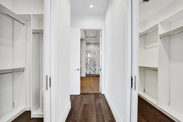 a view of a hallway with wooden floor and closet
